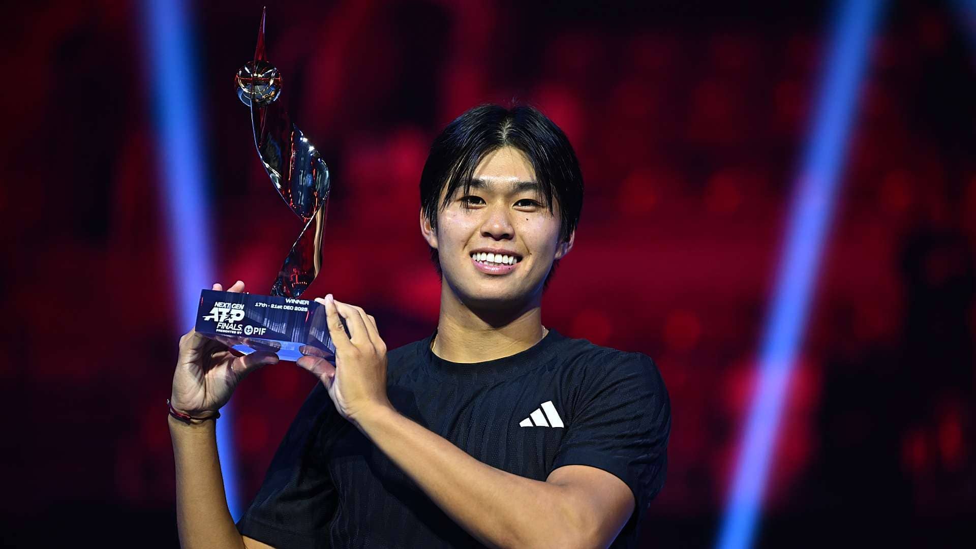 Learner Tien poses with the Next Gen ATP Finals winner trophy.