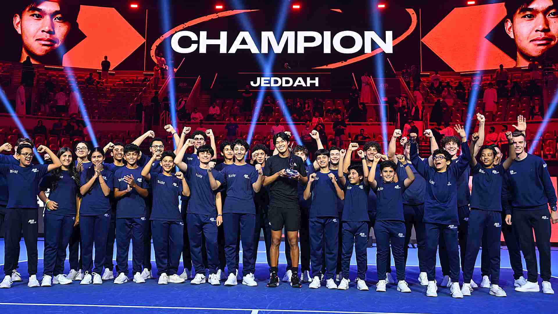 Learner Tien poses with the ballkids after winning the title.