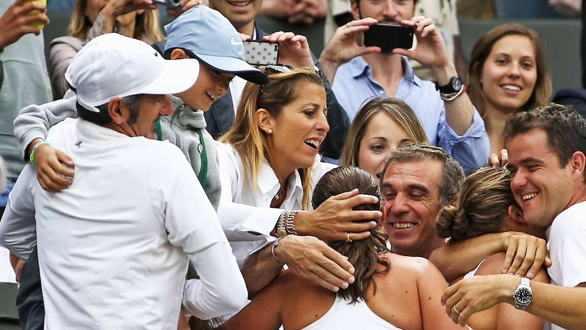Federico Cina in the arms of his father, Francesco (far left), at Wimbledon in 2014, following Sara Errani and Roberta Vinci's title run.